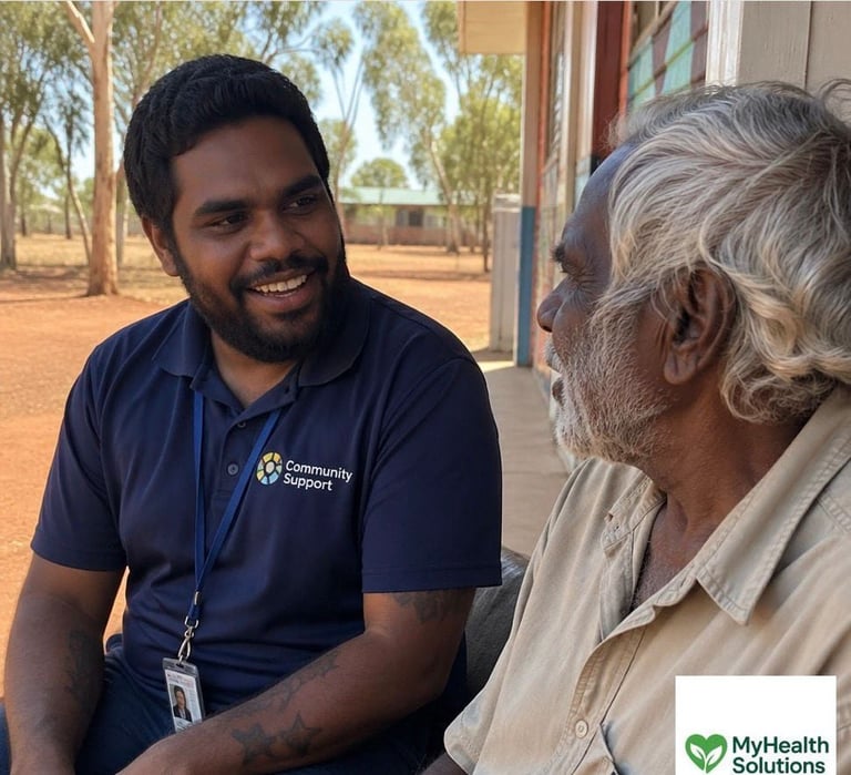 Community worker in navy polo shirt speaking with elderly man outdoors in rural setting with trees in background