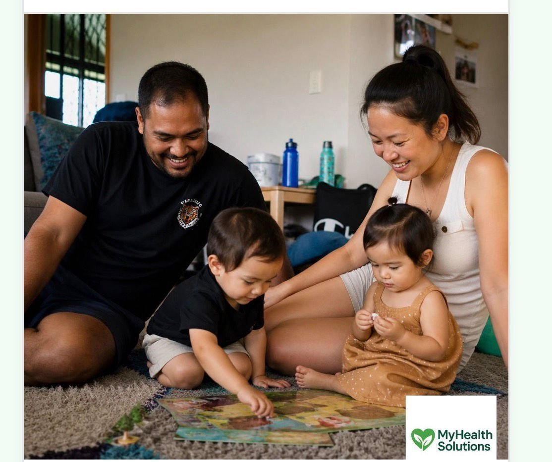 Family of four sitting on floor engaged in activity together, children and parents looking at items on carpet in living room