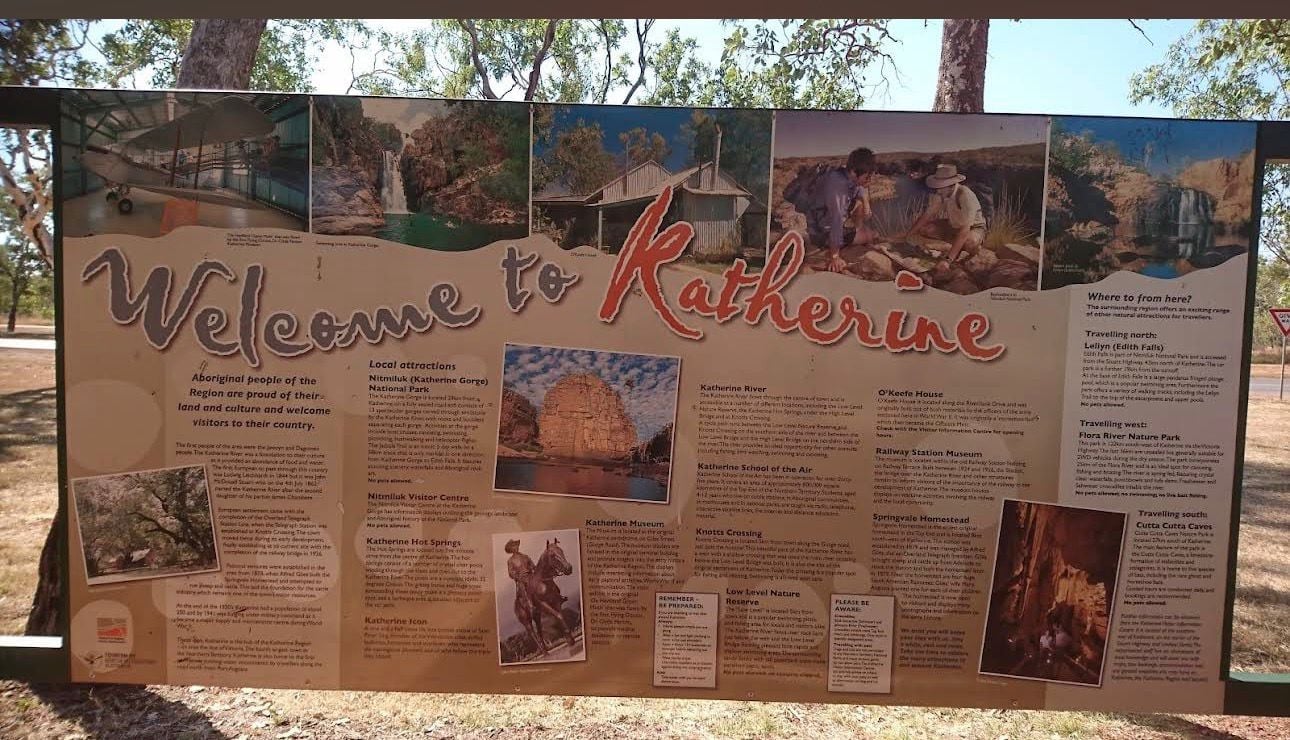 Welcome to Katherine informational sign display with historical photos and text panels in an outdoor park setting